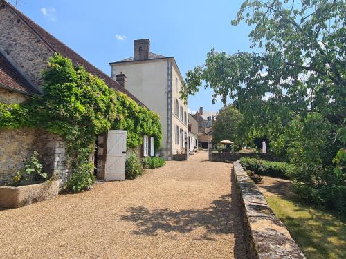 an empty street with ivy on the side of a building at Le Clos de Paris in Fresnay-sur-Sarthe
