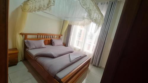 Cama pequeña en habitación con ventana en Room in Guest room - Charming Room in Kayove, Rwanda - Your Perfect Getaway, 