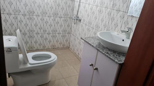 ein Bad mit einem WC und einem Waschbecken in der Unterkunft Room in Guest room - Charming Room in Kayove, Rwanda - Your Perfect Getaway 