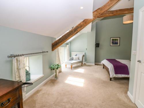a bedroom with a bed and a chair at Old Crow Trees Barn in Melling