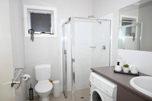 a white bathroom with a toilet and a shower at Mawson Red - Free Pool access -Onsite Parking-Netflix-5 mins to Mawson Interchange in Mawson Lakes