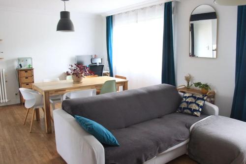 een woonkamer met een bank en een tafel bij Maison et jardin à 5 min de Vannes in Meucon