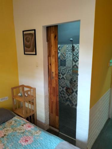 a bedroom with a shower with a bed and a door at BONNIE HOMESTAY Mui Ne in Mui Ne