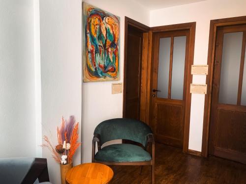a chair in a room with a painting on the wall at Casa Alegre Alaçatı in Alacati