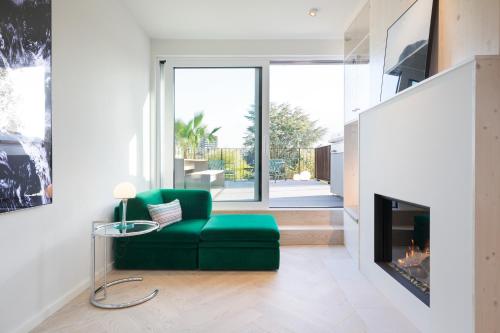 ein Wohnzimmer mit einer grünen Couch und einem Kamin in der Unterkunft HOMEFY - Luxury Art Apartment in Düsseldorf