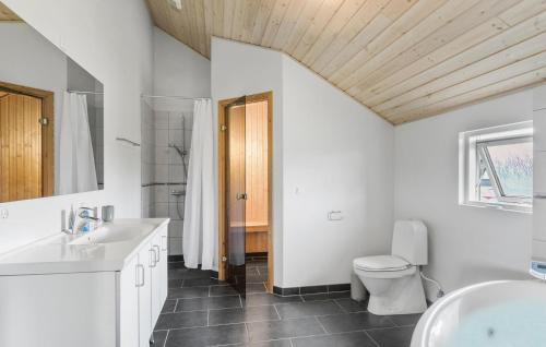 a bathroom with a white sink and a toilet at 4 Bedroom Lovely Home In Rdby in Kramnitse