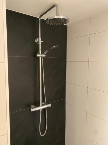 La salle de bains est pourvue d'une douche avec un pommeau de douche. dans l'établissement Bed and breakfast Carma Arnhem, à Arnhem