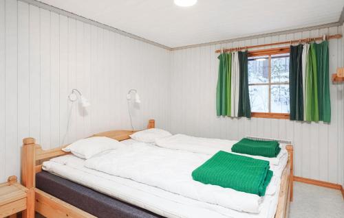 una camera da letto con un grande letto bianco con lenzuola verdi di Awesome Home In Lofsdalen With Kitchen a Lofsdalen
