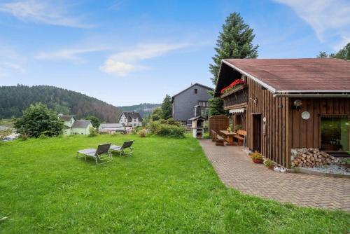 a house with a patio and a grass yard at Ferienhaus Panoramablick in Piesau