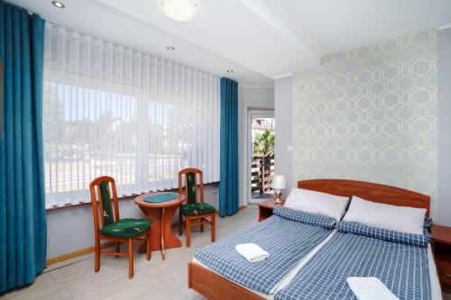 a bedroom with a bed and a table and chairs at Willa Karawela in Łeba