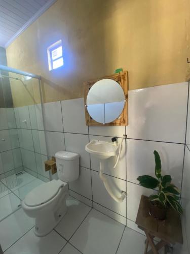 a bathroom with a toilet and a sink and a mirror at Pousada rancho sol nascente in Tutóia