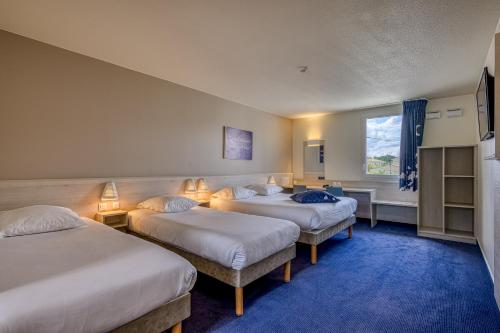 ein Hotelzimmer mit 3 Betten und einem Fenster in der Unterkunft ACE Hôtel Bordeaux Carbon Blanc in Carbon-Blanc