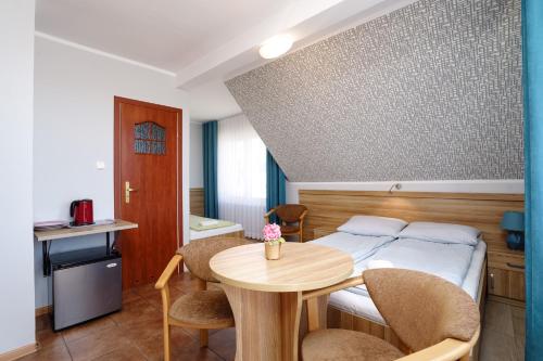 a room with a bed and a table and chairs at Willa Karawela in Łeba