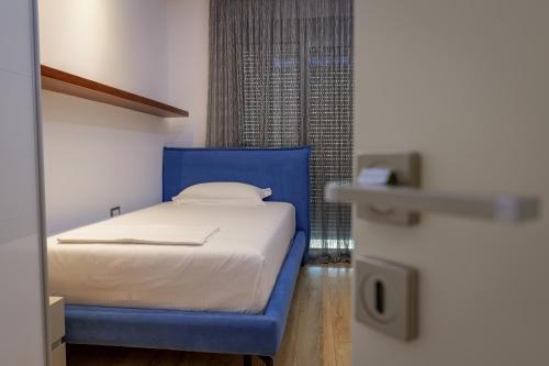a bedroom with a blue bed and a window at The View Luxury Apartment Center in Sarandë