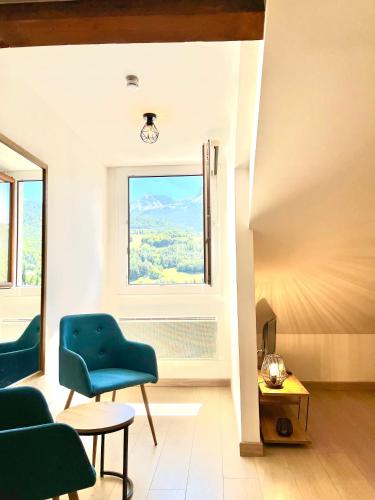 a living room with a blue chair and a window at Le Bellevue in Barcelonnette