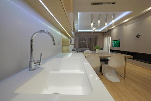 a kitchen with a sink and a table with chairs at The View Luxury Apartment Center in Sarandë