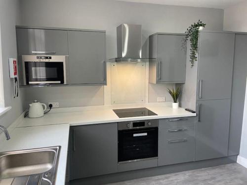 a kitchen with stainless steel appliances and white cabinets at Ivy Mount Boutique in Manchester