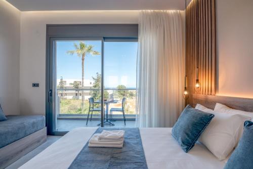 a bedroom with a bed and a balcony with a table at Litinakis Studios Sea View & Litinakis Studios Garden View 700 meters away in Agia Marina Nea Kydonias