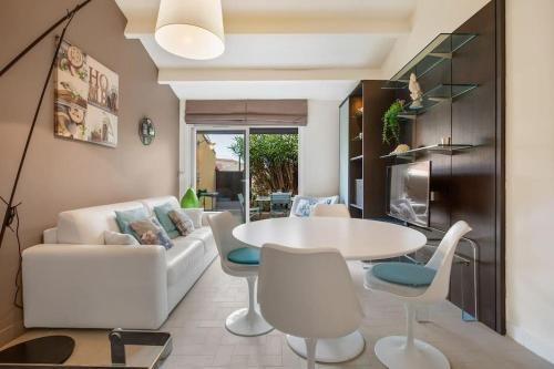 un salon avec une table et des chaises blanches dans l'établissement Petite Villa en bord de mer, au Cap d'Agde