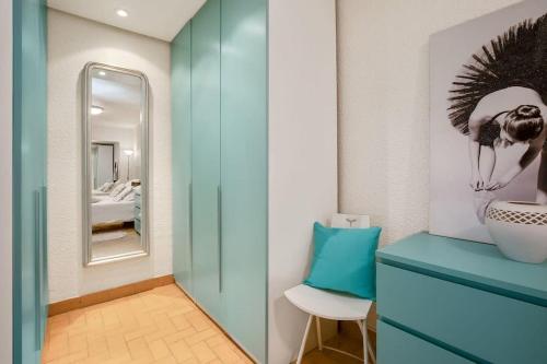 La salle de bains est pourvue d'une armoire bleue et d'un miroir. dans l'établissement Petite Villa en bord de mer, au Cap d'Agde