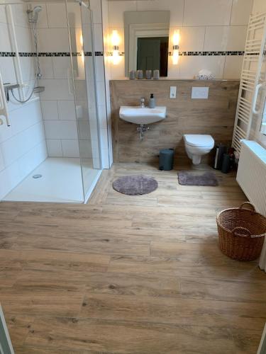 een badkamer met een wastafel, een douche en een toilet bij Ferienwohnung Bubikat in Borkum
