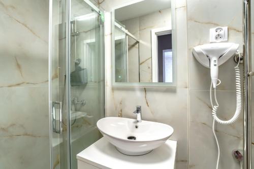 a bathroom with a white sink and a shower at Willa Karawela in Łeba