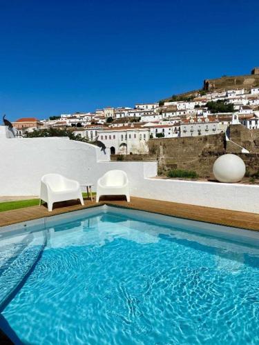 a swimming pool with a view of a city at Casa da Tia Amalia in Mértola