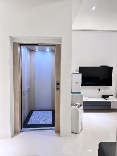 un bagno con doccia e una porta con televisore di Yun B&B a Dongshan