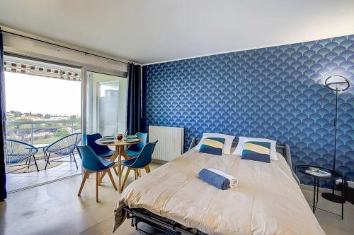 une chambre avec un lit et un mur bleu dans l'établissement Studio vue mer, piscine - tennis, à Antibes