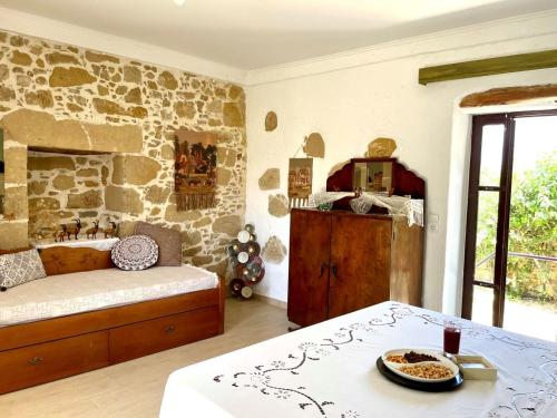 a room with a bed and a stone wall at Kyparissos Apartment II in Kissamos