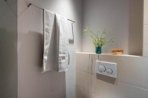 a white bathroom with a towel hanging on a wall at Val Blu Sport | Hotel | SPA in Bludenz