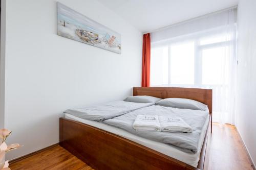 1 dormitorio con 1 cama con 2 toallas en BALATON A KERTBEN - Csodálatos panorámával rendelkező, közvetlen vízparti apartmanok, en Balatonfenyves