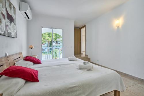 a bedroom with two beds with red pillows at Villa Fleming in Santanyi