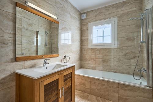 a bathroom with a tub and a sink and a shower at Villa Fleming in Santanyi
