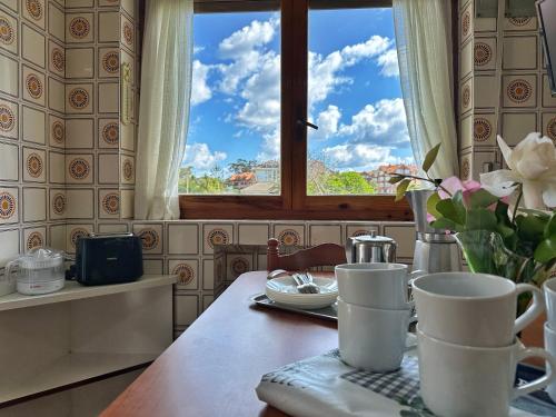 un tavolo con un vaso di fiori e una finestra di Villa La Hojarasca - 6820 a Noja
