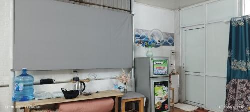 cocina con nevera y mesa en una habitación en H2_Homestay phố cổ _Check in tự động, en Hanói