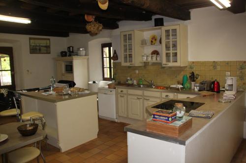 une cuisine avec des armoires blanches et un comptoir dans l'établissement ARDECHE La Ribeyre, à Les Assions