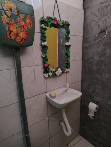 uma casa de banho com um lavatório e um espelho em Perto Do Aeroporto De Salvador - Dona Pitanga Hostel em Lauro de Freitas