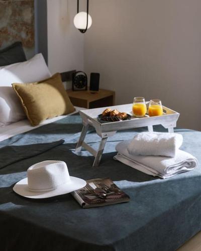 a hat and a tray of food on a bed at Blue Apartment in the Hill in Moírai