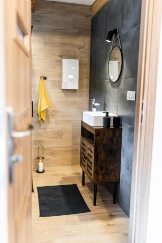 a bathroom with a sink and a mirror at Beskid Loft House - domki w górach in Sól