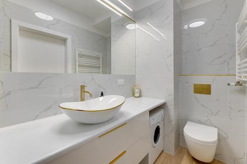 a bathroom with a bowl sink and a toilet at GRANO FLATS - Sobieszewo - Baltic Porto in Gdańsk