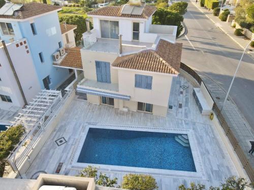 Paphos的住宿－Coral Azure，享有带游泳池的房屋的空中景致