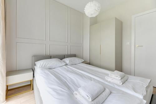 a bedroom with a white bed with towels on it at GRANO FLATS - Sobieszewo - Baltic Porto in Gdańsk