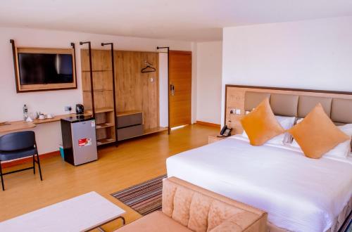 een slaapkamer met een groot wit bed en een bureau bij Muthu Warwick Mount Kenya Hotel, Nanyuki in Nanyuki