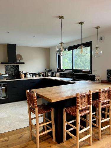 une cuisine avec une grande table et des chaises en bois dans l'établissement Villa vue lac, à Lacanau
