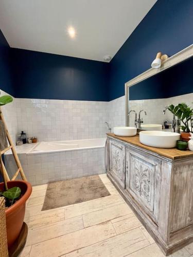 une salle de bain avec une vanité en bois avec deux lavabos et une baignoire dans l'établissement Villa vue lac, à Lacanau