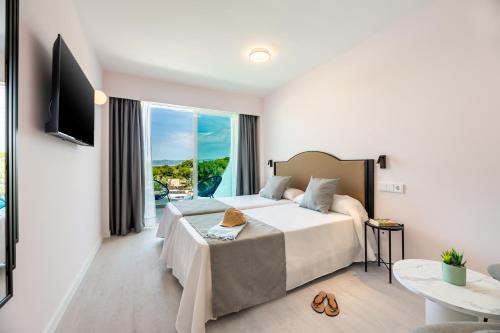 a hotel room with a bed and a balcony at Hotel Vibra Palma Cactus in Playa de Palma
