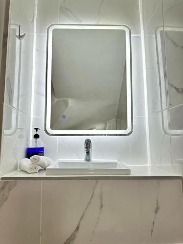 a bathroom sink with a mirror and towels on a shelf at Family house center&beach in Ierápetra