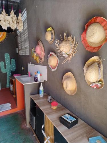 a room with straw hats on a wall at Perto Do Aeroporto De Salvador - Dona Pitanga Hostel in Lauro de Freitas