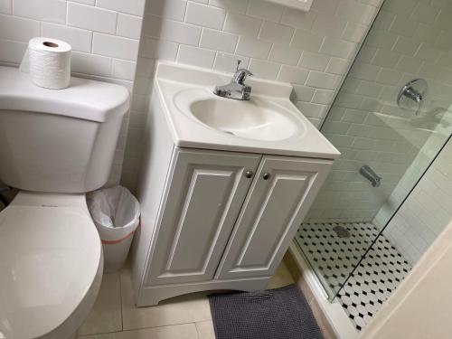 y baño con lavabo blanco y aseo. en Peaceful House near Manhattan en Queens